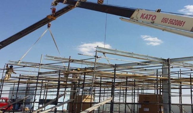 Mobile crane lifting canopy steel into place