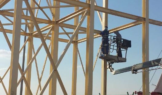 Worker on a lift platform at the steel tower
