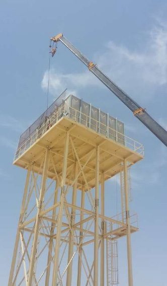 Water tank platform lifted onto a yellow steel tower